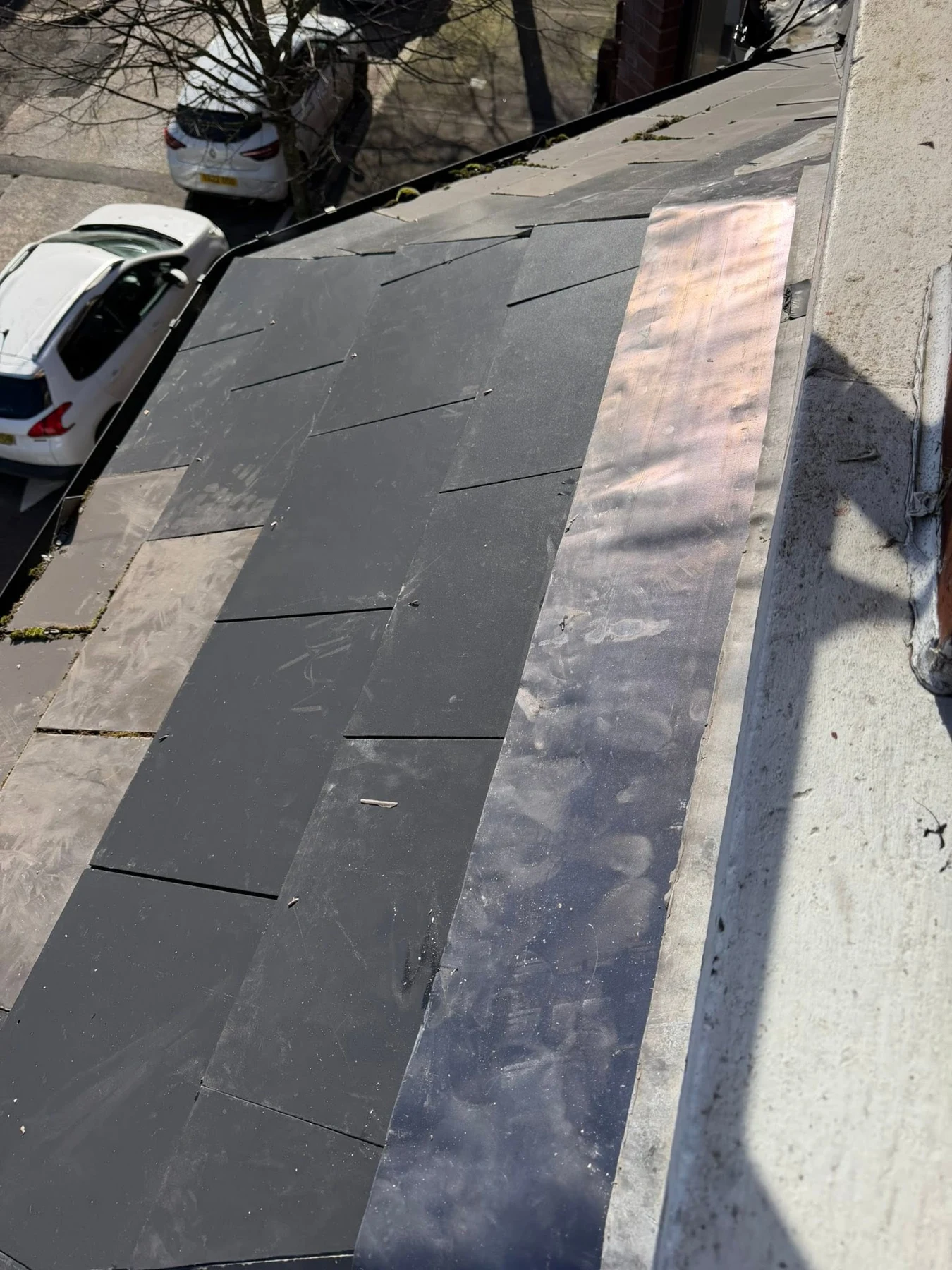 Lead flashing along the junction of a slate roof and wall
