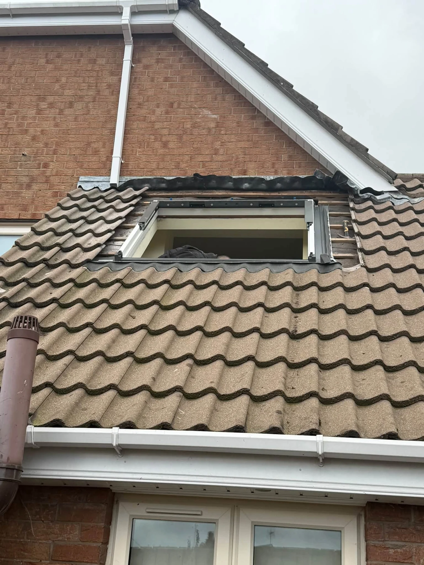 Roof window replacement in progress, with the old window removed